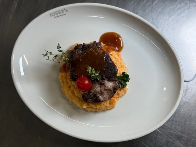 KAROTTEN-ZWIEBEL-STAMPF MIT KALBSBACKEN IN ROTWEINJUS (A,G)